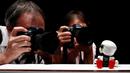 Wartawan mengabadikan Robot Mini Kirobo saat diperkenalkan di Tokyo, Jepang pada 27 September 2016. Kirobo Mini, merupakan robot seukuran genggaman tangan manusia ini dibuat untuk menemani anak bayi bermain. (REUTERS/Kim Kyung-Hoon)