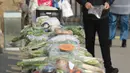 Seorang pria membeli sayuran di kios sayur tak berpenjaga di permukiman di Shijiazhuang, Provinsi Hebei, China utara (12/2/2020). Kios sayur tak berpenjaga itu didirikan untuk menyediakan sayuran kepada warga dengan kontak minimal sebagai upaya melawan epidemi virus corona. (Xinhua/Liang Zidong)