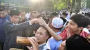 Sejumlah warga bersalaman dengan Presiden Joko Widodo usai melaksanakan salat id Hari Raya Idul Fitri 1 Syawal 1439 H di Lapangan Astrid, Kebun Raya Bogor, Jumat (15/6). (Merdeka.com/Arie Basuki)