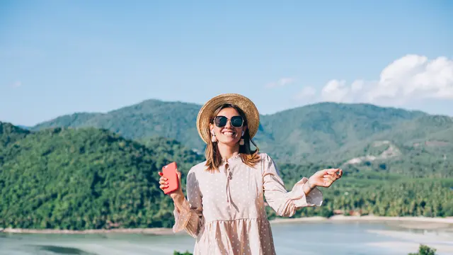 Seorang perempuan mengunjungi sebuah destinasi wisata di tepi laut (Foto Dok: Freepik/kroshka__nastya)