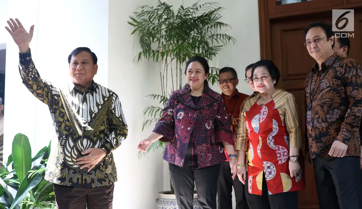 Ketua Umum Partai Gerindra Parbowo Subianto (kiri) melambaikan tangan saat berkunjung ke kediaman Ketua Umum PDIP Megawati Soekarnoputri di Jalan Teuku Umar, Jakarta, Rabu (24/7/2019). Pertemuan berlangsung tertutup. (Liputan6.com/Helmi Fithriansyah)