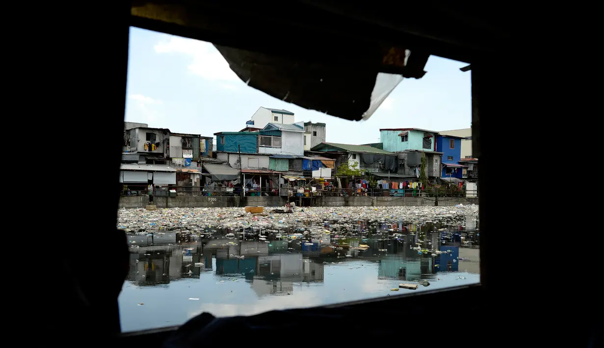 Teresita Gapayao (51) mengais sampah menggunakan rakit yang terbuat dari stereofoam di aliran Sungai Estero de Vitas di Tondo, Manila, Filipina, Kamis (21/4). Teresita menghasilkan sekitar Rp 50ribu/hari dari sampah yang dia kumpulkan. (Noel CELIS/AFP)
