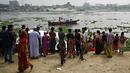 Orang-orang menyaksikan petugas pemadam kebakaran mencari korban kecelakaan feri di Sungai Shitalakshya di Narayanganj, Bangladesh (21/3/2022). Feri ML Afsar Uddin tenggelam di sungai setelah ditabrak kapal kargo. (AFP/Munir uz Zaman)