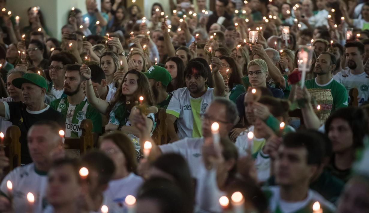 Ribuan fans dan kelurga korban pesawat Lamia 2933 menyalakan lilin memperingati satu tahun kecelakaan di Arena Conda stadium, Chapeco, Santa Catarina, Brasil, (28/11/2017). Sekitar 19 pemain Chapecoense meninggal. (AFP/Nelson Meida)