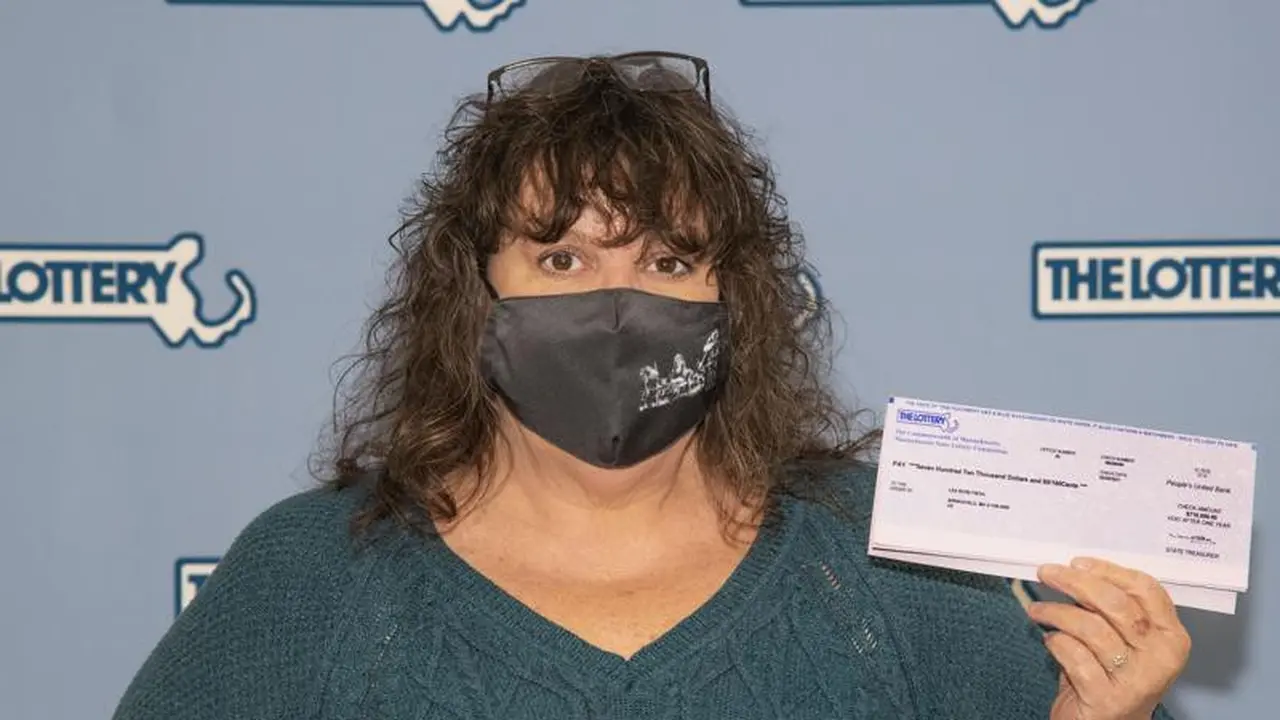Lea Rose Fiega memamerkan tiket lotere yang dimenangkannya, di markas Massachusetts Lottery Commission,di Boston, Amerika Serikat. (Photo credit: Massachusetts Lottery Commission Photo via AP)