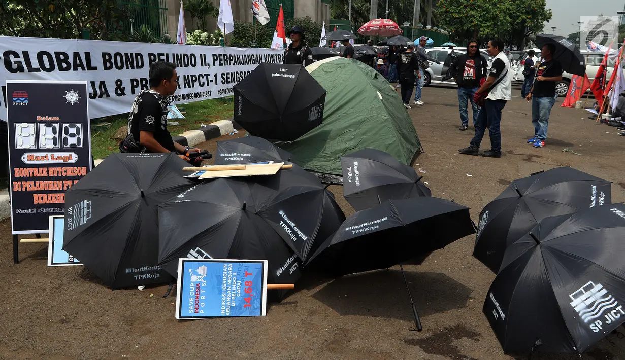 Serikat Pekerja JICT dan segenap pekerja pelabuhan Indonesia menggelar aksi di gedung DPR RI, Jakarta, Selasa (8/1). Dalam aksinya, pekerja membawa payung hitam dan simbol hitung mundur, tanda matinya keadilan bagi pekerja. (Liputan6.com/Johan Tallo)