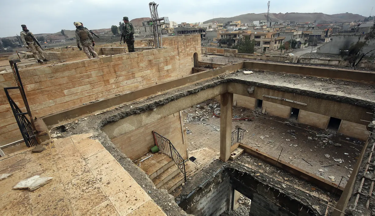 Tentara Irak mengamati kondisi Gereja St. George Monastery (Mar Guguis) yang rusak parah di Mosul, 22 Januari 2017. Tak hanya merusak, ISIS juga menjarah dan membakar salah satu gereja bersejarah di Irak tersebut pada 2014 lalu. (AHMAD AL-RUBAYE/AFP)