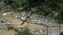 Reruntuhan menjatuhkan jutaan meter kubik es, lumpur, dan longsoran batu serta potongan kayu pohon Cemara yang menghantam desa Blatten yang berada tepat di bawah lembah. (Fabrice COFFRINI/AFP)