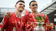 Bek Liverpool asal Skotlandia bernomor punggung 26, Andrew Robertson (kiri), dan bek Liverpool asal Inggris bernomor punggung 66, Trent Alexander-Arnold, merayakan kemenangan dengan trofi Liga Inggris di akhir pertandingan Liga Inggris antara Liverpool dan Crystal Palace di Anfield, Liverpool, barat laut Inggris pada 25 Mei 2025. Liverpool menyamakan kedudukan menjadi 1-1 melawan Crystal Palace. (Paul ELLIS/AFP)