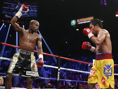 Mayweather Jr. tengah mengambil mengalihkan perhatian Pacquiao dengan mengangkat tangannya. (AP Photo/John Locher)
