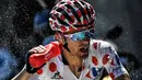Pemegang kaus polkadot asal Polandia, Rafal Majka, menyemprotkan air ke wajahnya saat beraksi dalam Etape 17 Tour de France berjarak 184,5 km antara Berne dan Finhaut-Emosson, Prancis (20/7/2016). (AFP/Jeff Pachoud)
