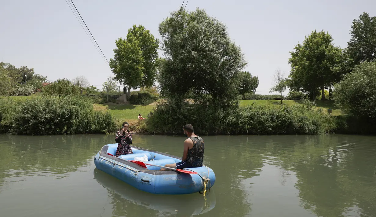 Umat muslim merayakan liburan Idul Fitri dengan rafting menyusuri Sungai Hasbani, Anak Sungai Yordan, di Kfar Blum, Israel, Rabu (27/5/2020). Pemerintah Israel mengurangi pembatasan aktivitas terkait pandemi virus corona COVID-19. (JALAA MAREY/AFP)