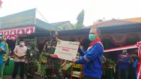 Area Manager PGE Area Karaha Roy Bandoro tengah memberikan simbolis bantuan CSR kepada Danramil Ciawi Kapten Deni Zenal Mutaqin dalam prorgam pemberdayaan ulat maggot dan azola. (Liputan6.com/Jayadi Supriadin)