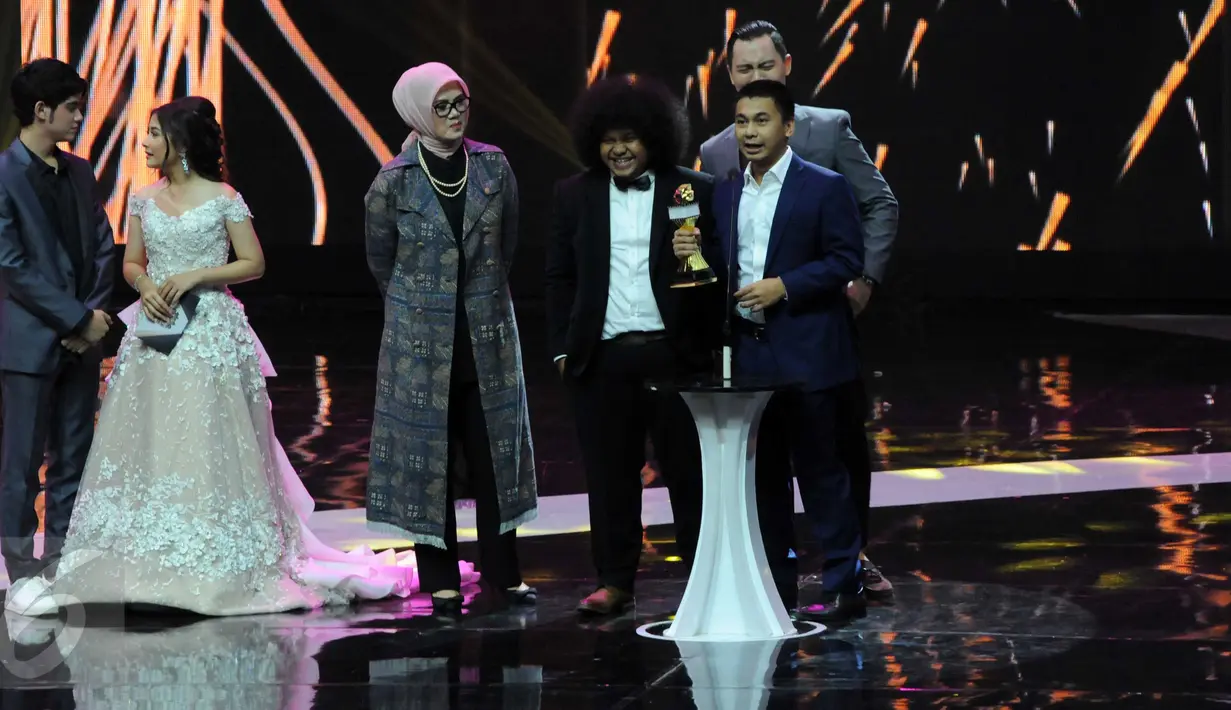 Aktor sekaligus sutradara, Raditya Dika (kanan) saat menerima  penghargaan sebagai Ensemble Talent Terbaik di Indonesia Box Office Movie Awards (IBOMA) 2016 dalam film "Single", Jakarta, Kamis (17/3). (Liputan6.com/Helmi Afandi)