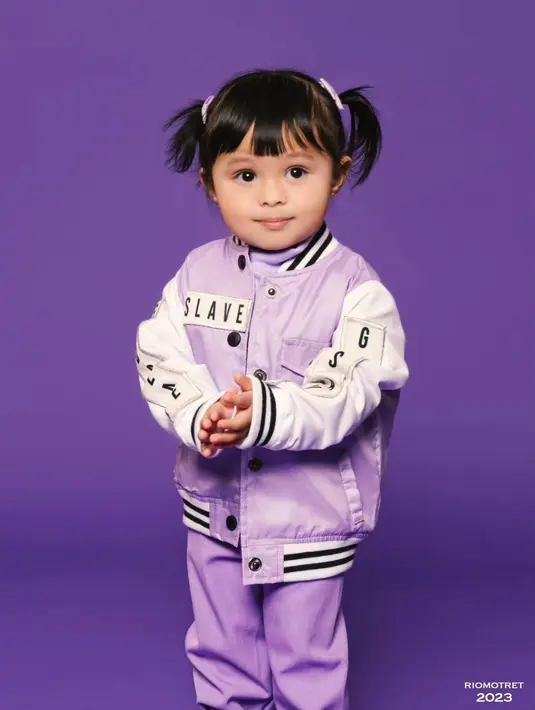 Mengenakan baseball jacket ungu putih dan celana panjang, Ameena Atta terlihat menggemaskan [@riomotret]