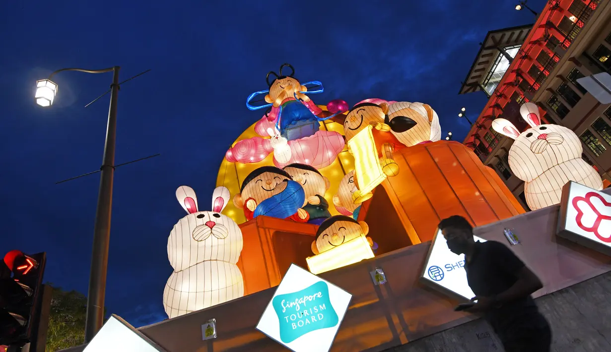 Seorang pejalan kaki melewati lentera-lentera cantik yang dinyalakan untuk menyambut Festival Tengah Musim Gugur di kawasan Pecinan, Singapura (29/9/2020). Tahun ini, festival tersebut jatuh pada 1 Oktober. (Xinhua/Then Chih Wey)