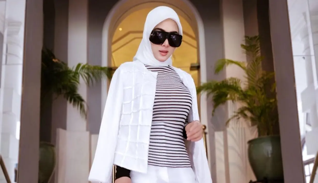 Tampil dalam hijab berwarna putih sesuai dengan busana yang digunakan, penampilan Syahrini satu ini terlihat memesona. Dirinya pun tak menggunakan aksesoris berlebih dan hanya mempercantik penampilan menggunakan kacamata hitam. (Liputan6.com/IG/@princessyahrini)