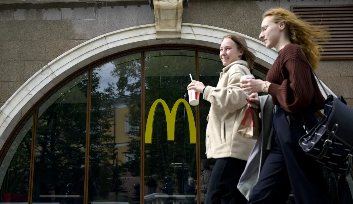 <p>Perempuan berjalan melewati restoran McDonald's yang tutup di Moskow, Rusia pada 16 Mei 2022. Raksasa makanan cepat saji asal Amerika, McDonald's, akan keluar dari pasar Rusia dan menjual bisnisnya di negara yang semakin terisolasi itu, kata perusahaan tersebut pada Senin kemarin. (Natalia KOLESNIKOVA / AFP)</p>