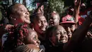 Presiden Kenya Uhuru Kenyatta foto bersama dengan warga selama tur trofi Piala Dunia FIFA Tour di State House di Nairobi (26/2). Trofi ini akan pindah ke 51 negara dan 91 kota pada saat pertandingan dimulai. (AFP Photo/Yasuyoshi Chiba)