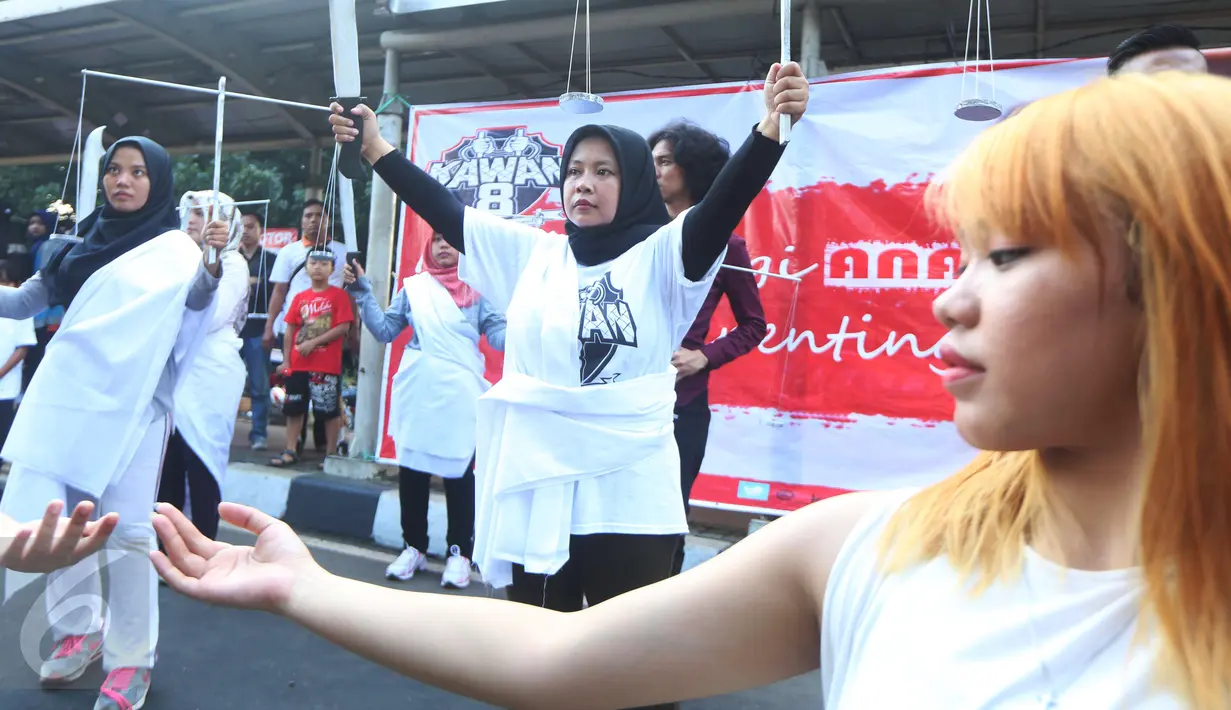 Ekpresi Relawan Kawan8 dan Mahasiswa IKJ saat flashmob di Jalan Jenderal Sudirman, Jakarta, Minggu (5/3). Acara tersebut bentuk kepedulian terhadap nasib para terpidana kasus Jakarta Intercultural School yang divonis penjara. (Liputan6.com/Helmi Afandi)