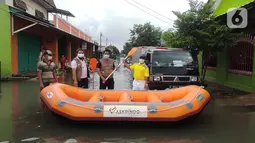 Karyawan PT. Askrindo secara simbolis memberikan bantuan perahu karet kepada warga korban banjir di Bekasi, Senin (22/02/2021). Bantuan perahu karet untuk proses evakuasi korban banjir diberikan di Pondok Timur Mas, Bekasi Selatan dan Perumnas III, Kota Bekasi. (Liputan6.com/Pool)