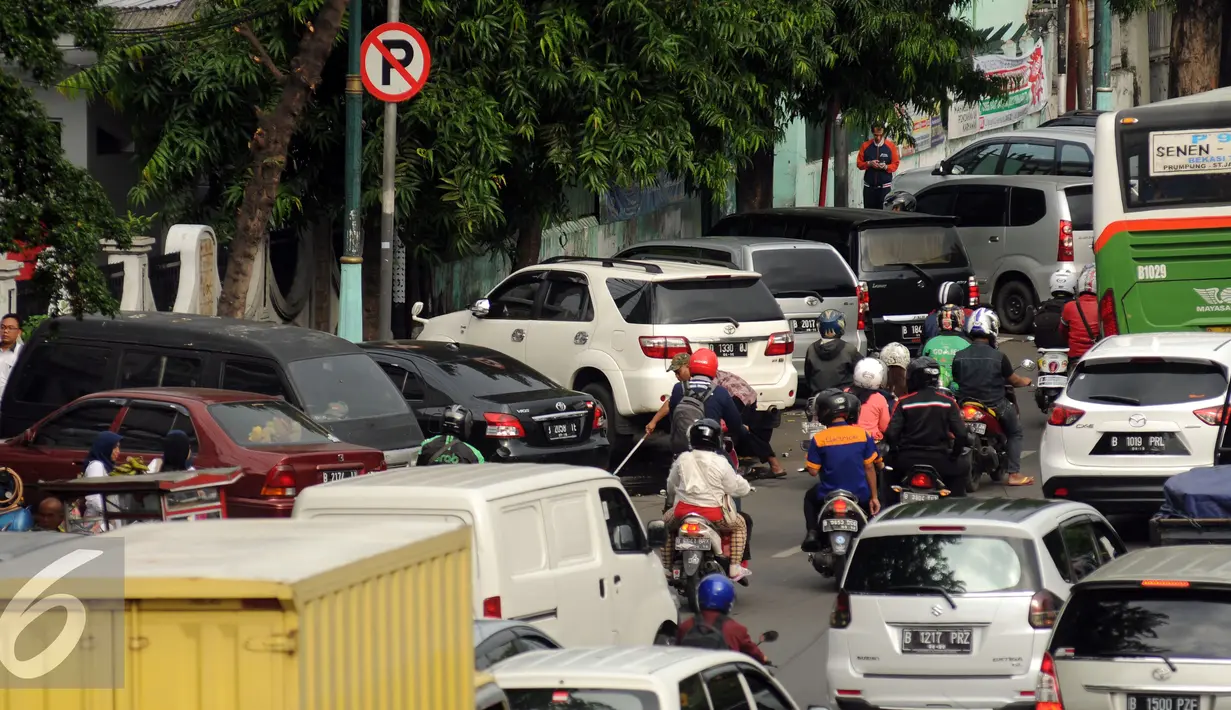 Sejumlah kendaraan terparkir di bawah tanda larangan di badan Jalan Kramat Raya, Jakarta, Senin (8/8). Rencananya, semua lokasi parkir on street akan dipasangi mesin terminal parkir elektronik (TPE). (Liputan6.com/Helmi Fithriansyah)