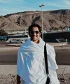 Arya Saloka tampil mengenakan ihram yang menjadi baju khusus untuk pria saat umrah. Ia pun melengkapi tampilannya dengan tas hitam dan kacamata hitamnya. [@arya.saloka]