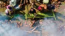 Pemandangan dari udara menunjukkan para peserta memasak lemang, hidangan nasi ketan tradisional yang dimasukkan ke dalam tabung bambu dan diisi dengan santan yang kemudian diletakkan di atas api, selama acara memasak massal di Blang Pidie, Kabupaten Aceh Barat Daya, Aceh, pada Sabtu 25 April 2026. (CHAIDEER MAHYUDDIN/AFP)
