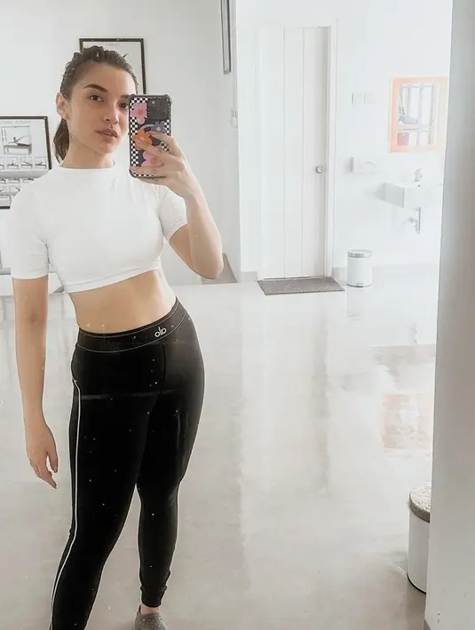 Mengenakan atasan crop top putih dipadukan celana hitam, Chelsea memamerkan perut ratanya.  credit: Instagram/(@chelseaoliviaa)