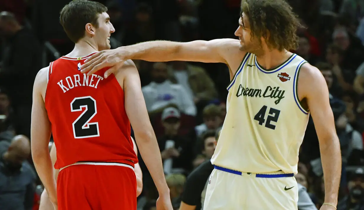 Pebasket Chicago Bulls, Luke Kornet, berbincang dengan pebasket Milwaukee Bucks, Robin Lopez, pada laga NBA di United Center, Selasa (31/12/2019). Milwaukee Bucks menang 123-102 atas Chicago Bulls. (AP/Matt Marton)