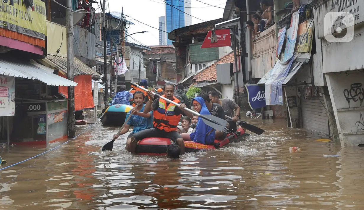 Petugas mengevakuasi warga korban banjir menggunakan perahu karet di kawasan Karet Pasar Baru Barat, Jakarta, Selasa (25/2/2020). Banjir yang terjadi sejak subuh akibat luapan Kanal Banjir Barat tersebut merendam ratusan rumah hingga setinggi dua meter. (merdeka.com/Arie Basuki)