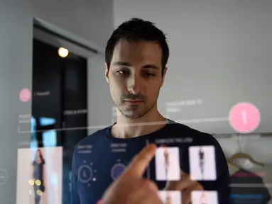  Peneliti Oak Labs, Wesley Bliss saat menggunakan cermin pintar Oak Fitting Room di sebuah butik, New York, AS (7/2). Cermin yang dilengkapi dengan teknologi RFID ini mampu mendeteksi baju yang dibawa pembeli. (AFP Photo / Jewel Samad)