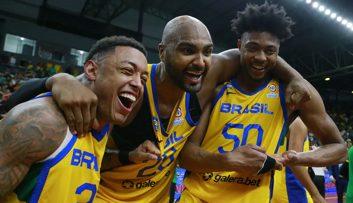 Selebrasi tiga pemain Tim Bola Basket Brasil (dari kiri) Yago dos Santos, Lucas Mariano dan Bruno Caboclo setelah mengalahkan Amerika Serikat pada kualifikasi Piala Dunia Bola Basket FIBA 2023 di Santa Cruz do Sul, Brasil (26/2/2023). Seperti Spanyol, Brasil juga tercatat telah mengoleksi dua gelar juara Piala Dunia Bola Basket FIBA yang diraihnya secara beruntun pada edisi 1959 di Cile dan edisi 1963 saat menjadi tuan rumah. Brasil juga akan menjadi kontestan pada Piala Dunia Bola Basket FIBA 2023. (AFP/Silvio Avila)