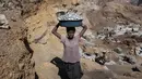 Bocah perempuan mengangkat bongkahan batu saat bekerja di sebuah tambang di Ouagadougou, Burkina Faso, 21 Desember 2015. Ini untuk menyelamatkan masa depan 168 juta anak yang sudah bekerja di usia dini. (NABILA EL Hadad / AFP)