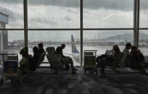Pelancong menunggu di aula keberangkatan di Bandara Internasional Hong Kong di Hong Kong, Minggu, 8 Oktober 2023. Sejumlah penerbangan di Hong Kong dibatalkan pada hari Minggu ketika Badai Tropis Koinu mendekati kota Cina selatan setelah menyebabkan setidaknya satu orang tewas dan lebih dari 300 terluka di Taiwan (AP Photo / Emily Wang)