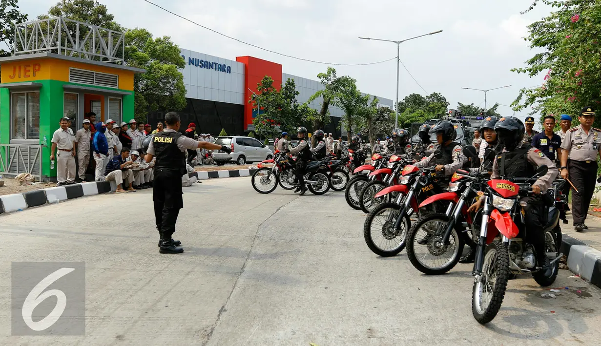 Petugas kepolisian tampak berjaga untuk mengantisipasi isu sweeping buruh di kawasan industri Pulogadung, Jakarta, Selasa (24/11/2015). Buruh menuntut dicabutnya Peraturan Pemerintah No 78 Tahun 2015 tentang Pengupahan. (Liputan6.com/Yoppy Renato)