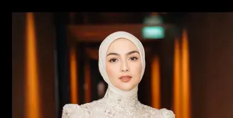 Tampil anggun dalam balutan dress brokat berwarna beige, Citra memadukannya dengan hijab segi empat yang dililit rapi ke belakang. Siluet clean dan warna lembut menciptakan kesan feminin sekaligus classy. [@ciraciki].