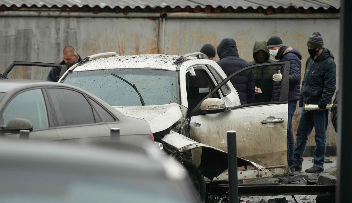 Insiden ini terjadi di halaman salah satu kompleks perumahan di Moskow. Tampak dalam foto, para penyidik bekerja di lokasi kejadian di mana Letnan Jenderal Fanil Sarvarov, kepala Direktorat Pelatihan Operasional Staf Umum Angkatan Bersenjata Rusia, tewas akibat alat peledak yang ditempatkan di bawah mobilnya di Moskow, Senin 22 Desember 2025. (AP Photo)