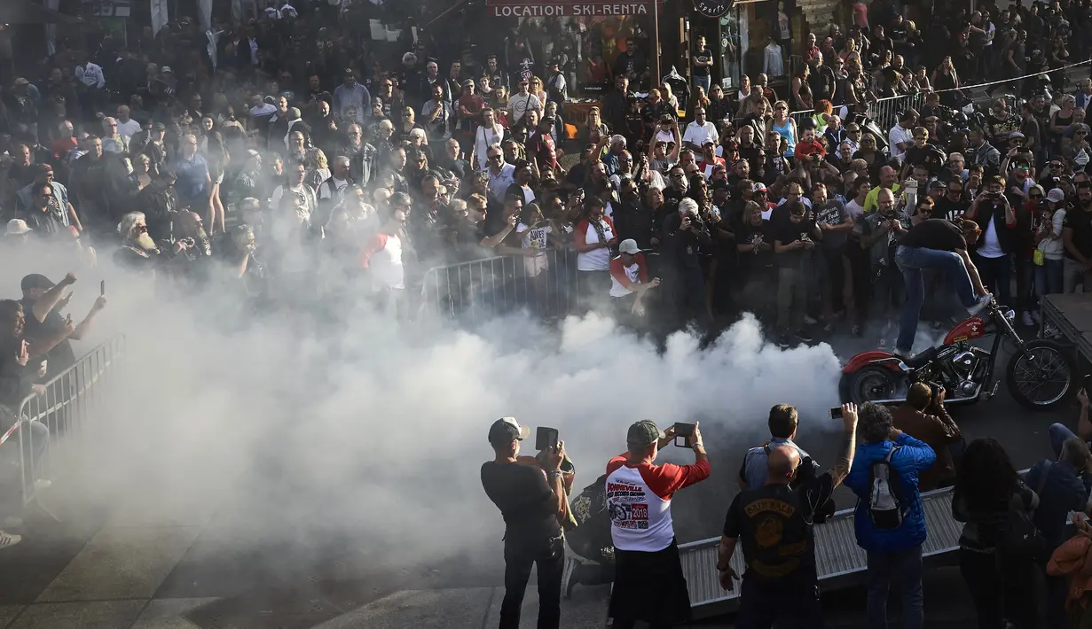 Penggemar sepeda motor gede (moge) menonton atraksi berdiri diatas motor saat acara 6th Morzine-Avoriaz Harley Days 2017, Morzine (15/7). Acara ini diselenggarakan oleh HOG (Harley Owners Group).  (AFP Photo/Jean-Philippe Ksaizek)