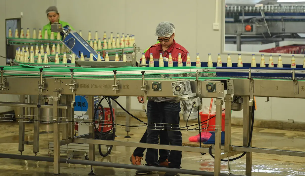 Pekerja memantau jalur produksi susu kedelai di sebuah pabrik di Nanning, Guangxi, China, Selasa (12/3). Dalam dua bulan pertama tahun ini, produksi industri China menunjukkan perlambatan stabilisasi ekonomi terbesar kedua di dunia itu. (STR/AFP)