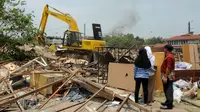 Sejumlah orang menyaksikan proses pembongkaran ratusan kios di Terminal Depok, Jawa Barat, (8/10/2014). Sebanyak 150 bangunan kios dan 80 lapak PKL ditertibkan guna pembangunan Terminal Terpadu Kota Depok, Jawa Barat. (Liputan6.com/Helmi Fithriansyah)