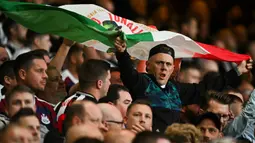 Seorang pendukung membentangkan bendera Italia saat Sandro Tonali melakukan comeback bersama Newcastle pada laga Carabao Cup 2024/2025 melawan Nottingham Forest di City Ground, Nottingham, Inggris, Kamis (29/08/2024) WIB. (AFP/Paul Ellis)