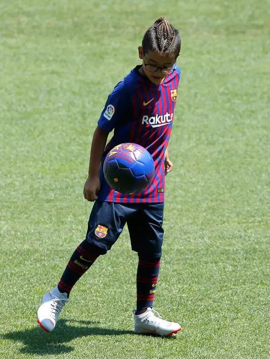 Putra gelandang baru Barcelona Arturo Vidal, Alonso Vidal mengontrol bola selama presentasi dirinya di stadion Camp Nou, Spanyol, (6/8). Vidal dibeli Barcelona dari klub Jerman, Bayern Munchen. (AP Photo/Manu Fernandez)
