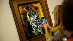 Pengunjung mengambil gambar lukisan berjudul Femme en pleurs karya Pablo Picasso di Museum Picasso, Paris, Prancis, Jumat (23/3). Pameran ini kerja sama Musée national Picasso-Paris dan Museo Nacional Centro de Arte Reina Sofía. (AP Photo/Christophe Ena)