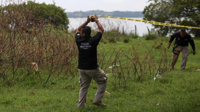 Polisi menutup daerah ditemukannya kuburan massal rahasia di Arbolillo, negara bagian Veracruz, Meksiko, Jumat (7/9). Jaksa Negara Bagian Veracruz, Jorge Winckler mengatakan mayat-mayat itu dikubur setidaknya sekitar dua tahun lalu. (AP/Felix Marquez)