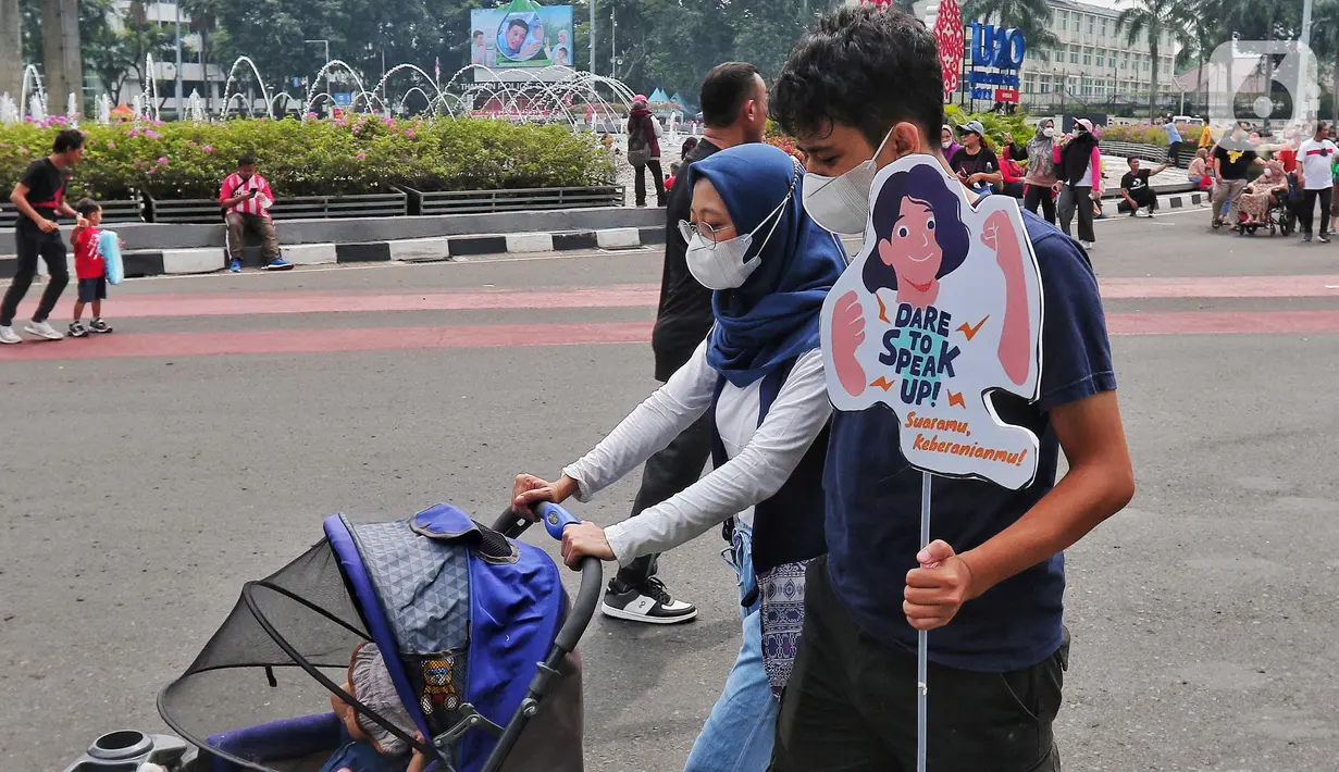 Masyarakat membawa poster sosialisasi UU TPKS saat Car Free Day di kawasan Bundaran HI, Jakarta, Minggu (25/9/2022). Kampanye Undang-undang Tindak Pelaku Kekerasan Seksual (UU TPKS)  tersebut dilakukan agar masayarakat dapat mengetahui UU ini menjadi payung hukum bagi korban kekerasan seksual. Bukan hanya korban yang bisa melaporkan tindak kekerasan seksual, tapi bagi yang mendengar atau melihat juga bisa melaporkan. (Liputan6.com/Angga Yuniar)