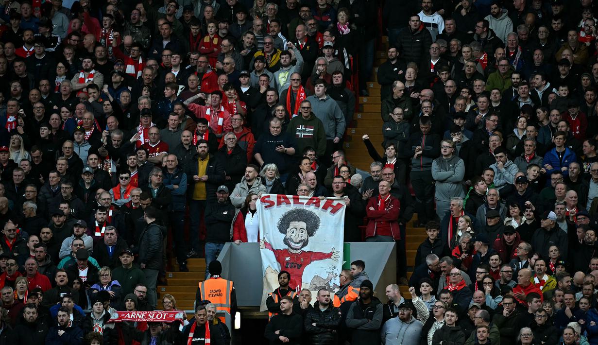 Suporter Liverpool membentangkan poster bergambar Mohamed Salah saat laga lanjutan Liga Inggris 2024/2025 melawan Chelsea di Anfield, Liverpool, Inggris, Minggu (20/11/2024). (AFP/Paul Ellis)