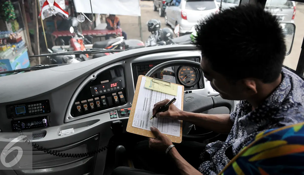 Petugas bus Transjakarta melakukan pengecekan jadwal keluar masuk bus di Terminal Depok, Jumat (22/7). Perubahan rute tersebut bertujuan agar bus bisa mengangkut penumpang di sekitar Bumi Perkemahan Cibubur. (Liputan6.com/Yoppy Renato)