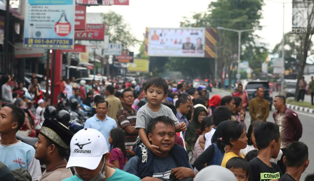 Seorang anak saat ingin melihat kirab atau arak-arakan acara resepsi Kahiyang Ayu Siregar-Bobby Nasution di Kota Medan, Sumatera Utara Minggu (26/11). (Liputan6.com/Johan Tallo)
