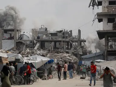 Warga Palestina berlarian menyelamatkan diri saat serangan Israel menghantam rumah keluarga Hmeid di Jabalia, Jalur Gaza Utara, 15 Mei 2025. (Bashar TALEB/AFP)